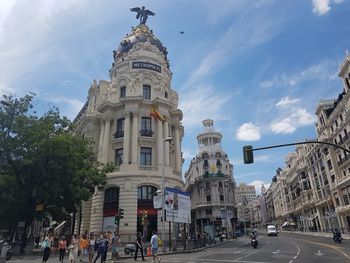 Group of people on road amidst buildings in city