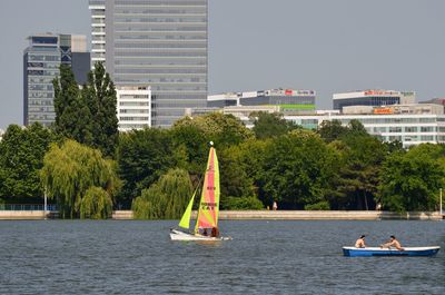 Man on boat in city against sky