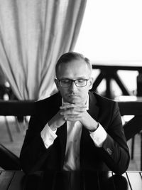 Businessman with eyes closed sitting at table in restaurant