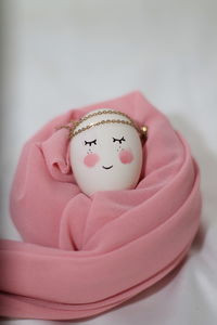 Close-up of figurine on pink cake