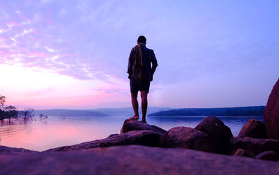 Rear view of man looking at sea against sky