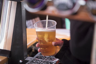 Close-up of hand holding beer glass