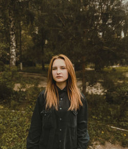 Portrait of beautiful young woman standing in forest