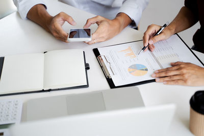 Midsection of man using laptop on table