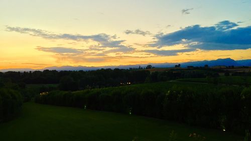 Scenic view of field against sky at sunset