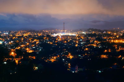 High angle view of city lit up at night