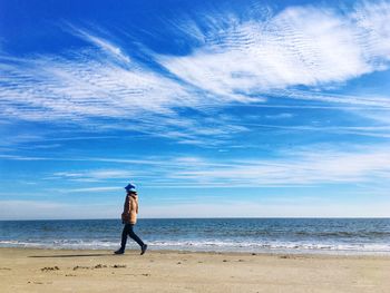 Full length of man standing on beach against sky