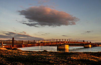 Bridge over sea against sky during sunset