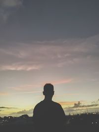 Rear view of silhouette man standing against sky during sunset