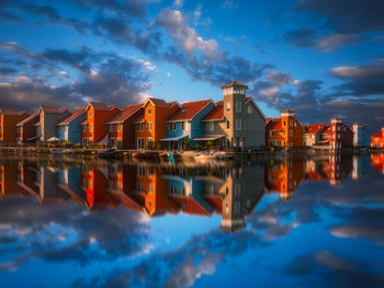 Reflection of buildings in lake against sky