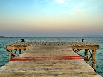 Pier on sea at sunset