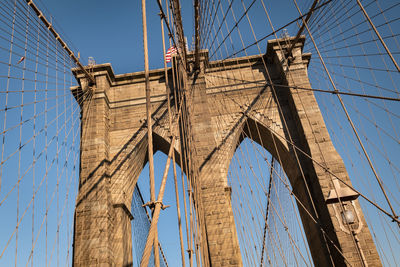 Low angle view of suspension bridge against blue sky