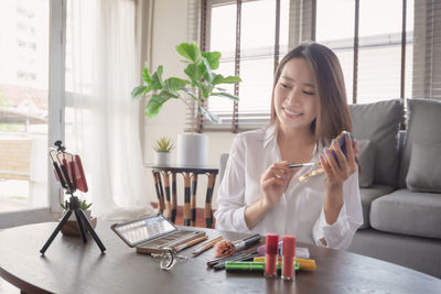 Young woman sitting on table at home