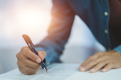 Midsection of businessman working at blueprint