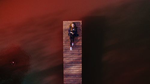 Sky drone view of a woman laying around red water