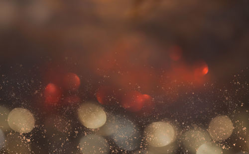 Defocused image of rain drops on illuminated glass