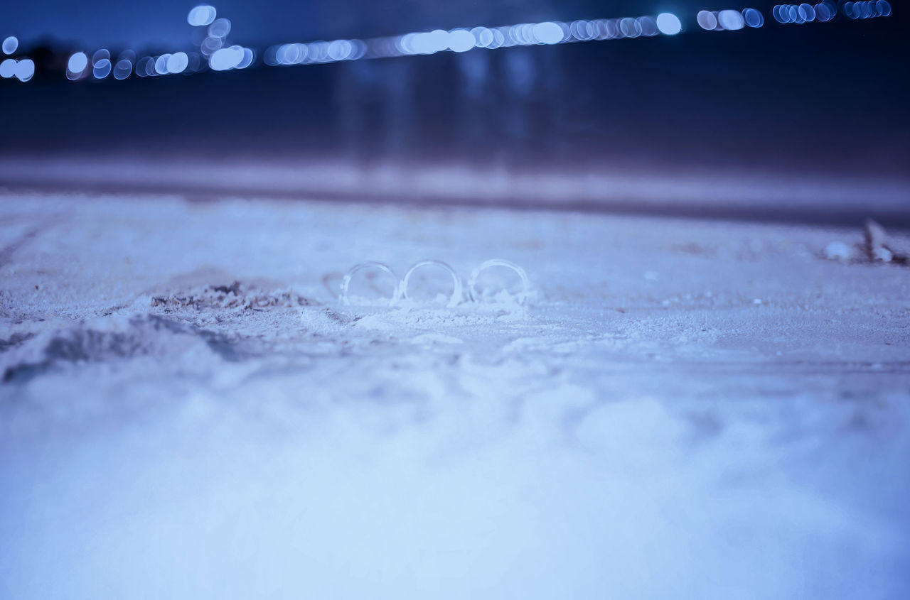 selective focus, no people, surface level, close-up, illuminated, night, cold temperature, outdoors, sport, flooring, pattern, textured, water, nature, transportation, text, winter, western script