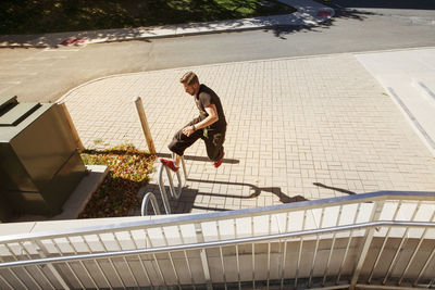 High angle view of man doing stunt on railing in city