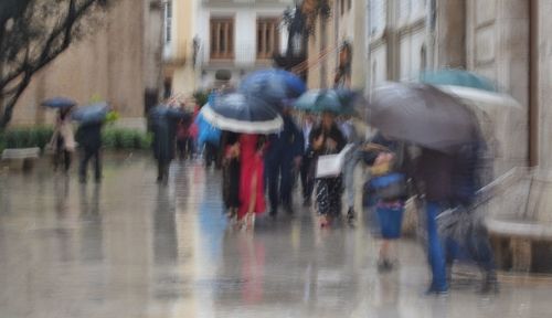 People walking on wet street in rainy season