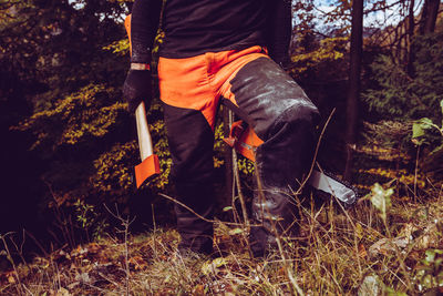 Woodcutter man walking in the forest woodcutter equipment and tools hard work outdoor