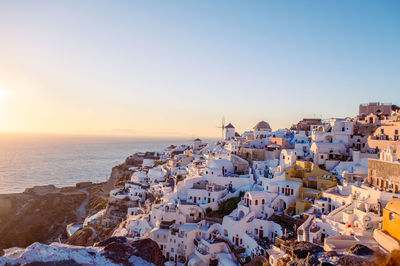 Aerial view of townscape by sea against clear sky