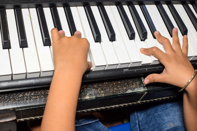 Asian boy playing the synthesizer or piano. cute little kid learning how to play piano