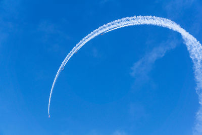 Low angle view of vapor trail against blue sky