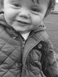 Close-up portrait of smiling baby wearing jacket