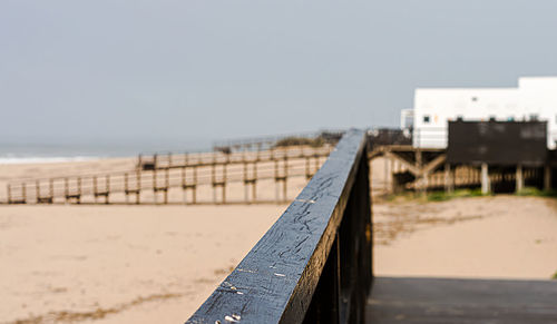 Pier on beach against clear sky