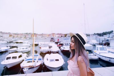 Woman standing at harbor against clear sky