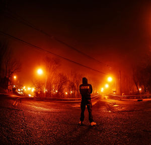 Man standing on road at night