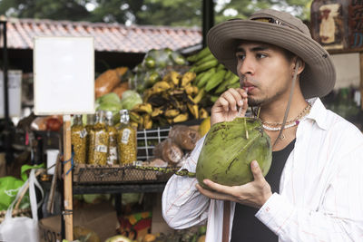 Latin man drinking coconut water