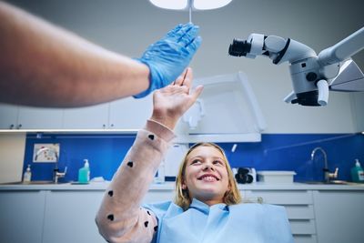Smiling girl giving high-five to dentist