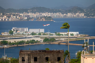 Buildings by sea against sky