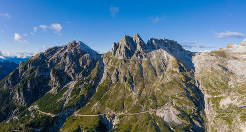 Panoramic view of the mangart mountain range in the julian alps with mountain pass road, slovenia.