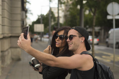 Man taking selfie with friend while standing on road