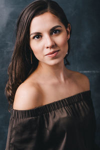 Portrait of a beautiful young woman with long hair and uncovered shoulders