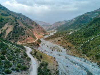 Scenic view of road by mountains against sky