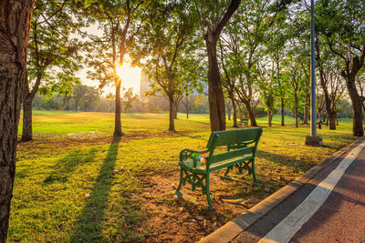 Park bench on field against sky