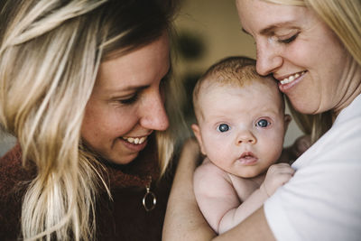 Smiling mothers holding newborn baby