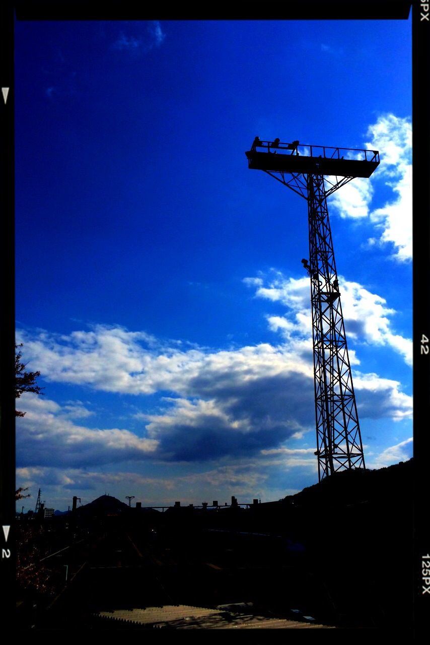 sky, transfer print, built structure, low angle view, auto post production filter, blue, electricity pylon, fuel and power generation, architecture, industry, technology, construction site, connection, electricity, development, cloud, silhouette, crane - construction machinery, cloud - sky, building exterior