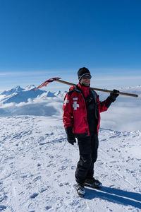 Man standing on snowcapped mountain against sky