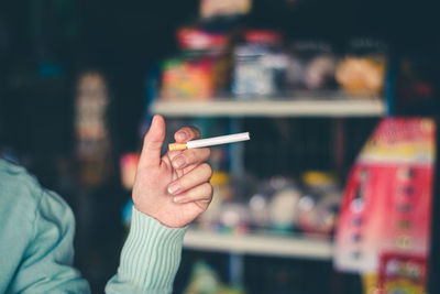 Close-up of hand holding cigarette