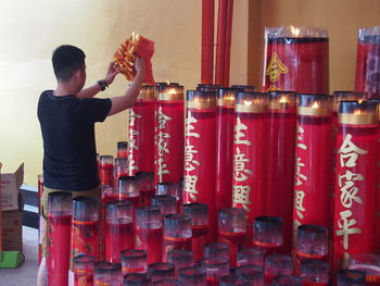 Man by large candles in temple 