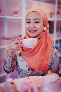 Portrait of a young woman drinking coffee