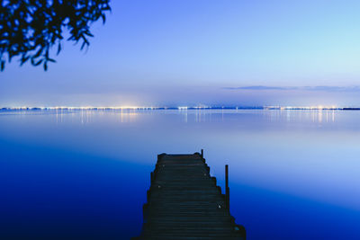 Pier over lake against blue sky