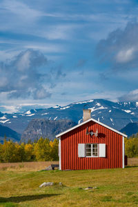 Scenic view of house and mountains against sky