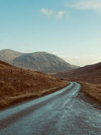 Road amidst mountains against sky