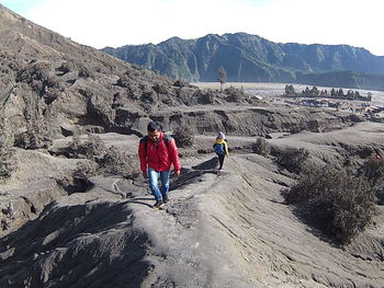 People walking on rocks against mountains