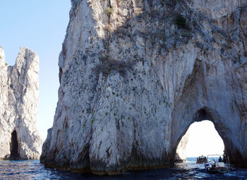 Scenic view of rock formation in sea against sky